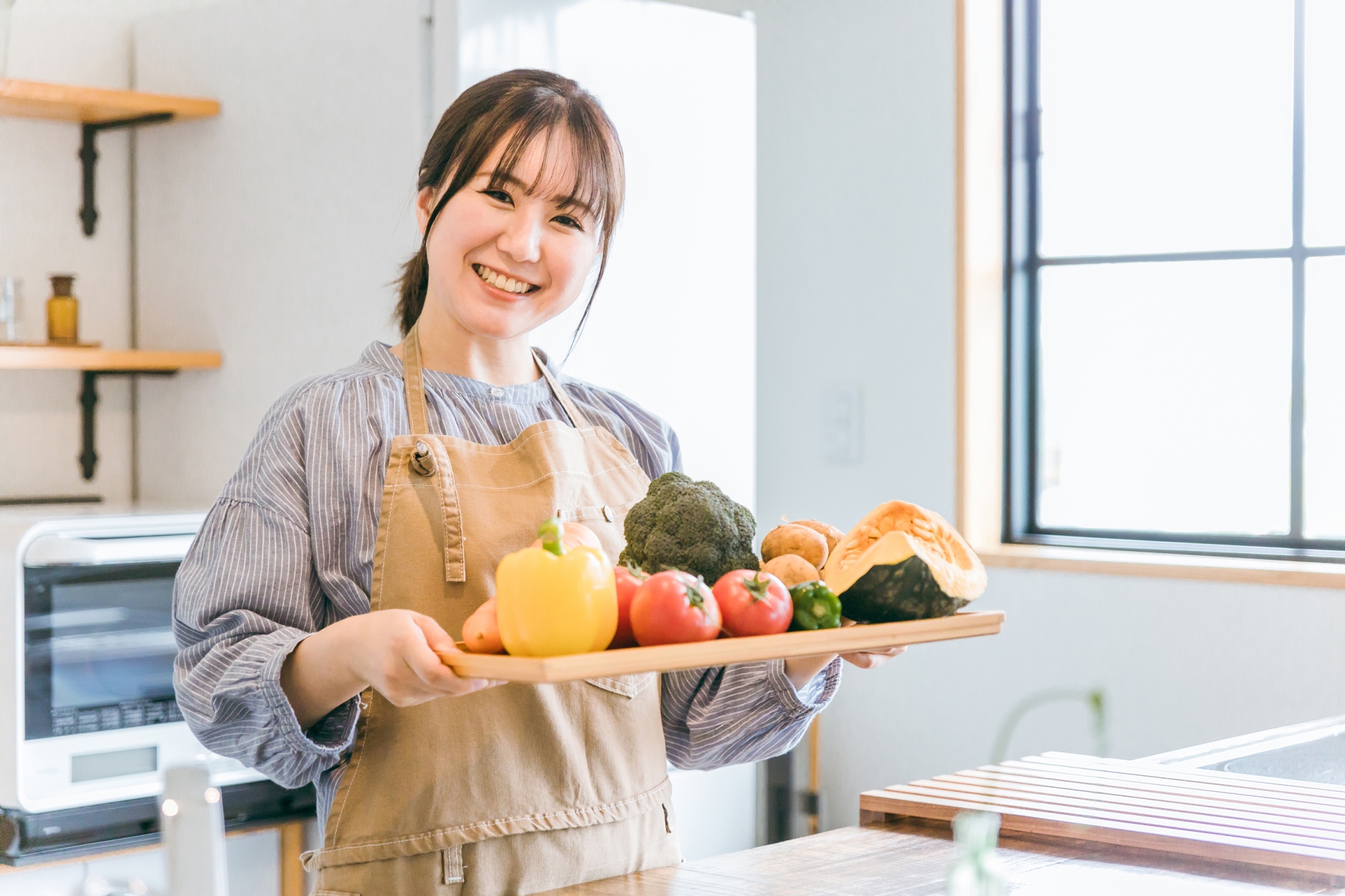 家事がめんどう キッチンに立つ笑顔の主婦