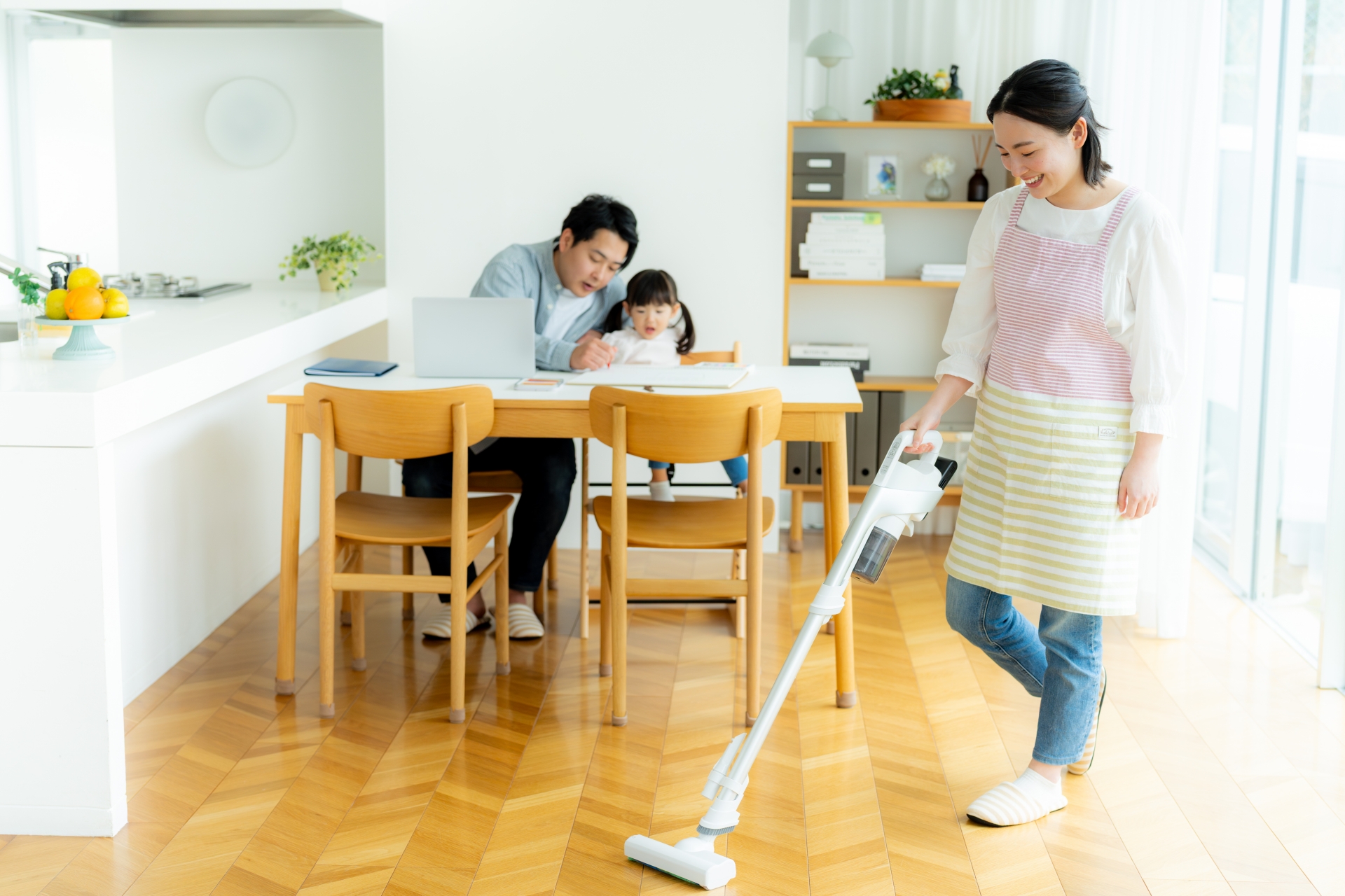 家事がめんどう 笑顔で掃除機をかける主婦