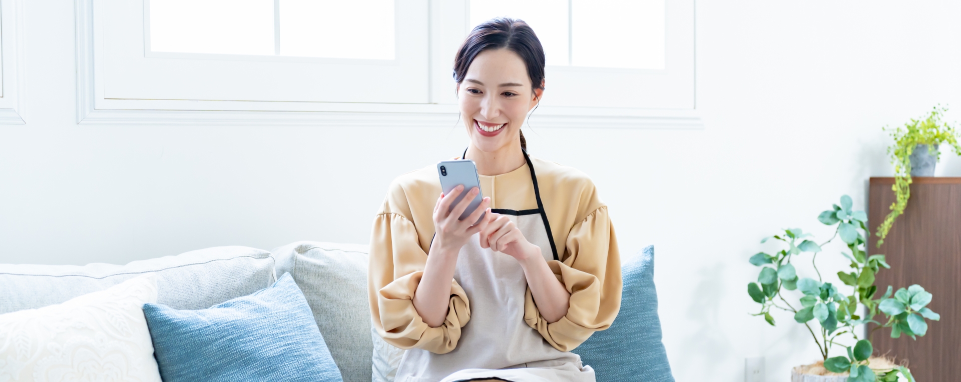 家事代行危険 笑顔でスマホを操作する主婦