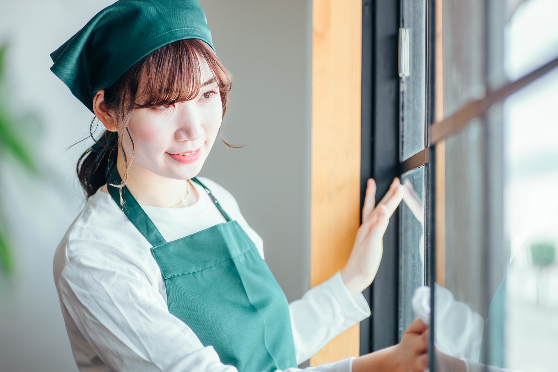 大掃除 順番 窓を拭いている女性のイメージ画像