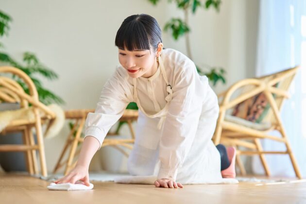部屋を拭き掃除する若い女性