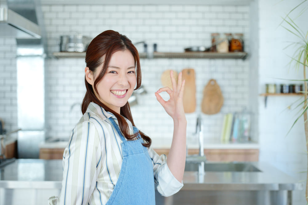 キッチンでOKサインをする女性