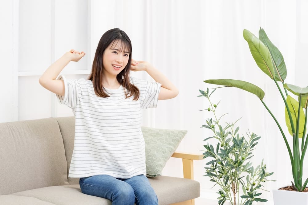 部屋で深呼吸する女性